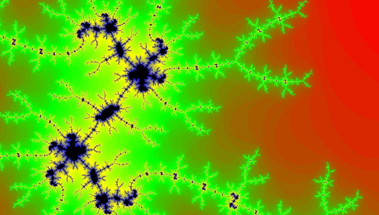 Daniel Britten smiling in a red plaid shirt and tortoise shell glasses